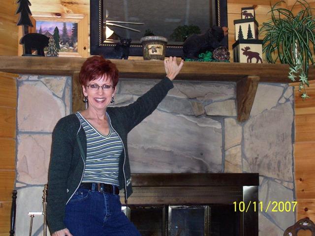 100_3121.JPG - Pam posing in front of the fireplace.