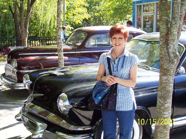 100_3238.JPG - Pam with some of the vintage cars at Dollywood.
