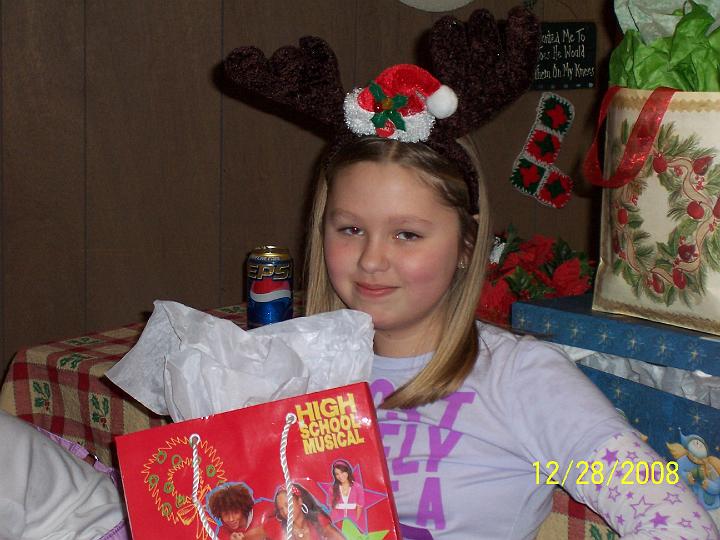 100_4420.JPG - Kaitlyn wondering how long she has to wear the reindeer antlers.