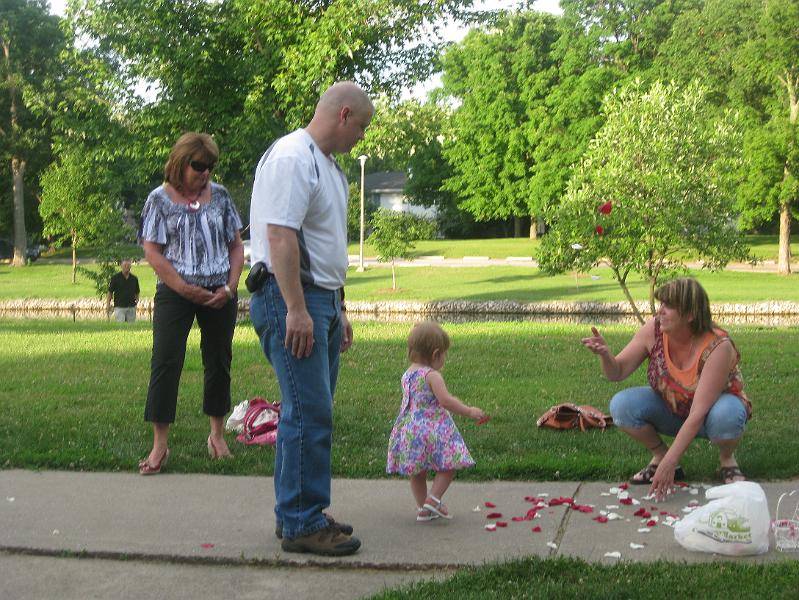 IMG_0618.JPG - Grandma Diane, Grandpa Eric and Nana Penny showing Macie how to pick up the rose petals.