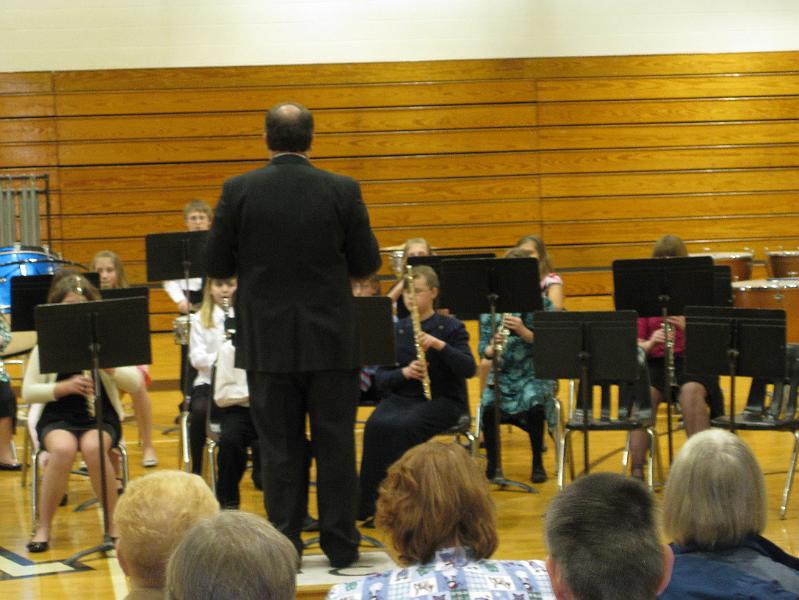IMG_0322.JPG - At Kaitlyn's spring band concert.  You couldn't see any of the kids faces for the music stands.  Those are her legs to the right of the conductor, in the green dress and black tights!