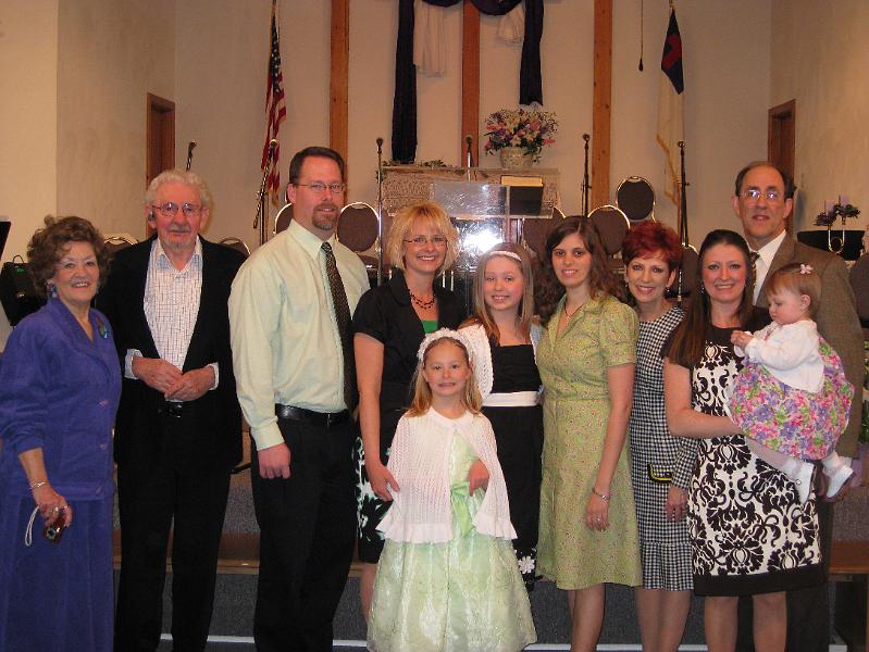 IMG_0384.JPG - Family photo:  Nana & Papa, Don, Joy, Sydney & Kaitlyn, Robin, Pam, Misty & Macie, and Mark.  One of these years we'll remember to quit taking flash photos with that plexiglass podium behind us!